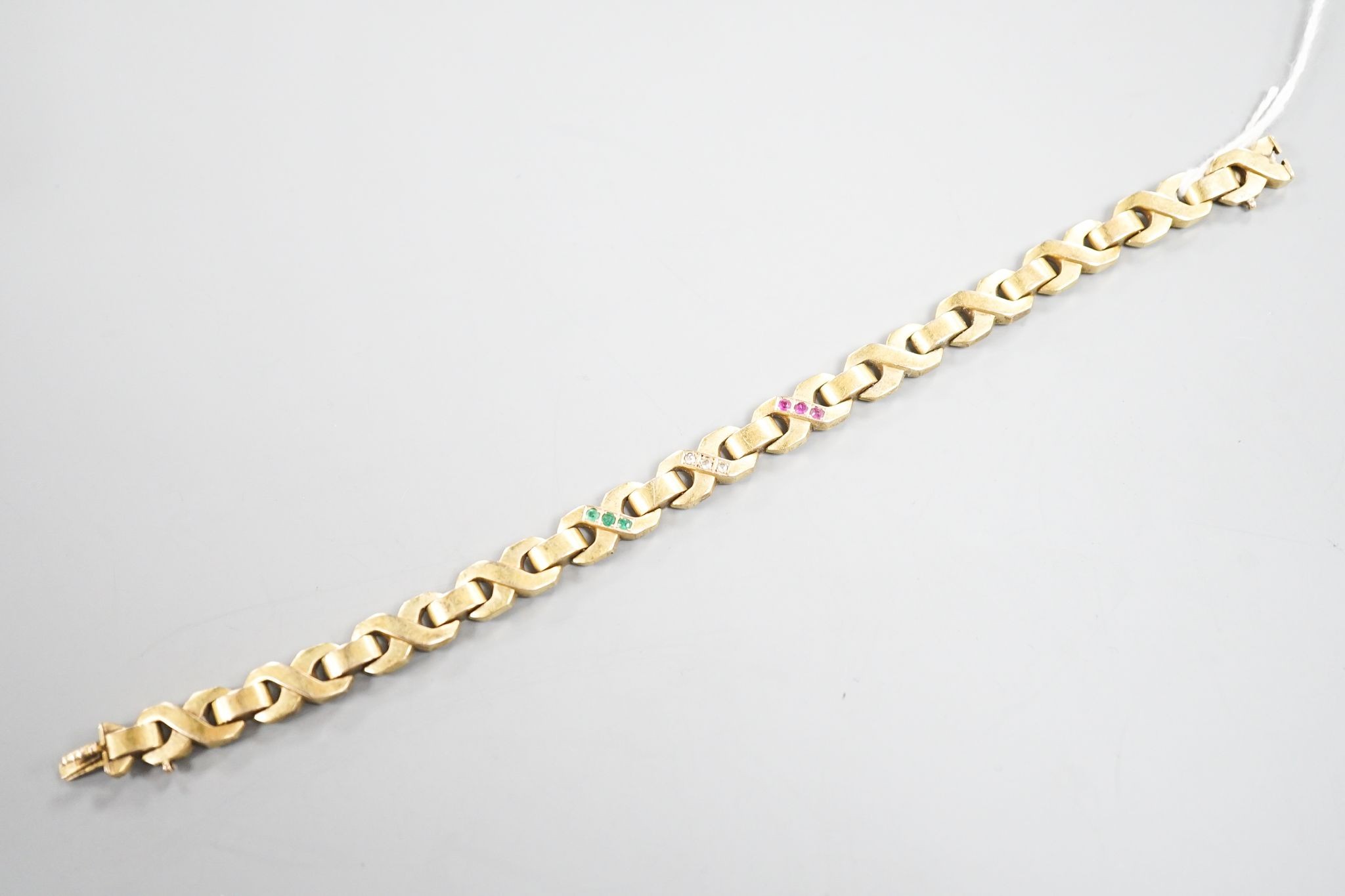 A modern continental yellow, metal, ruby, emerald and diamond set bracelet, 18.3cm, gross weight 14.5 grams.